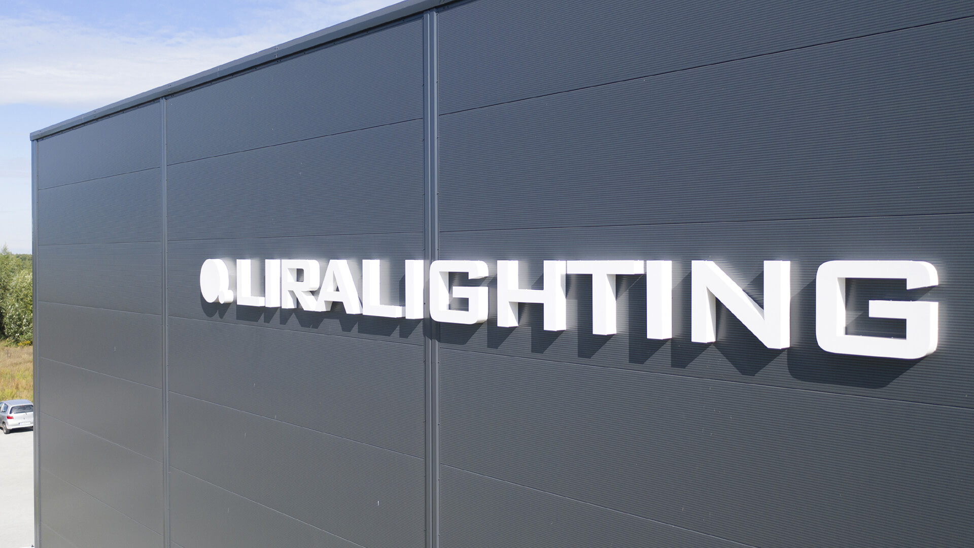 Letras luminosas LED 3D sobre una nave industrial en blanco.